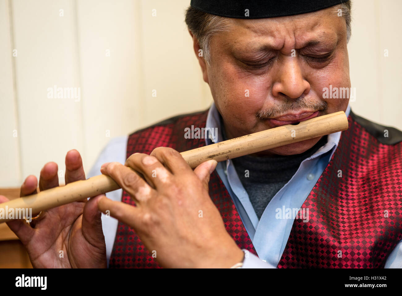 Nepalese man playing a traditional flute Stock Photo