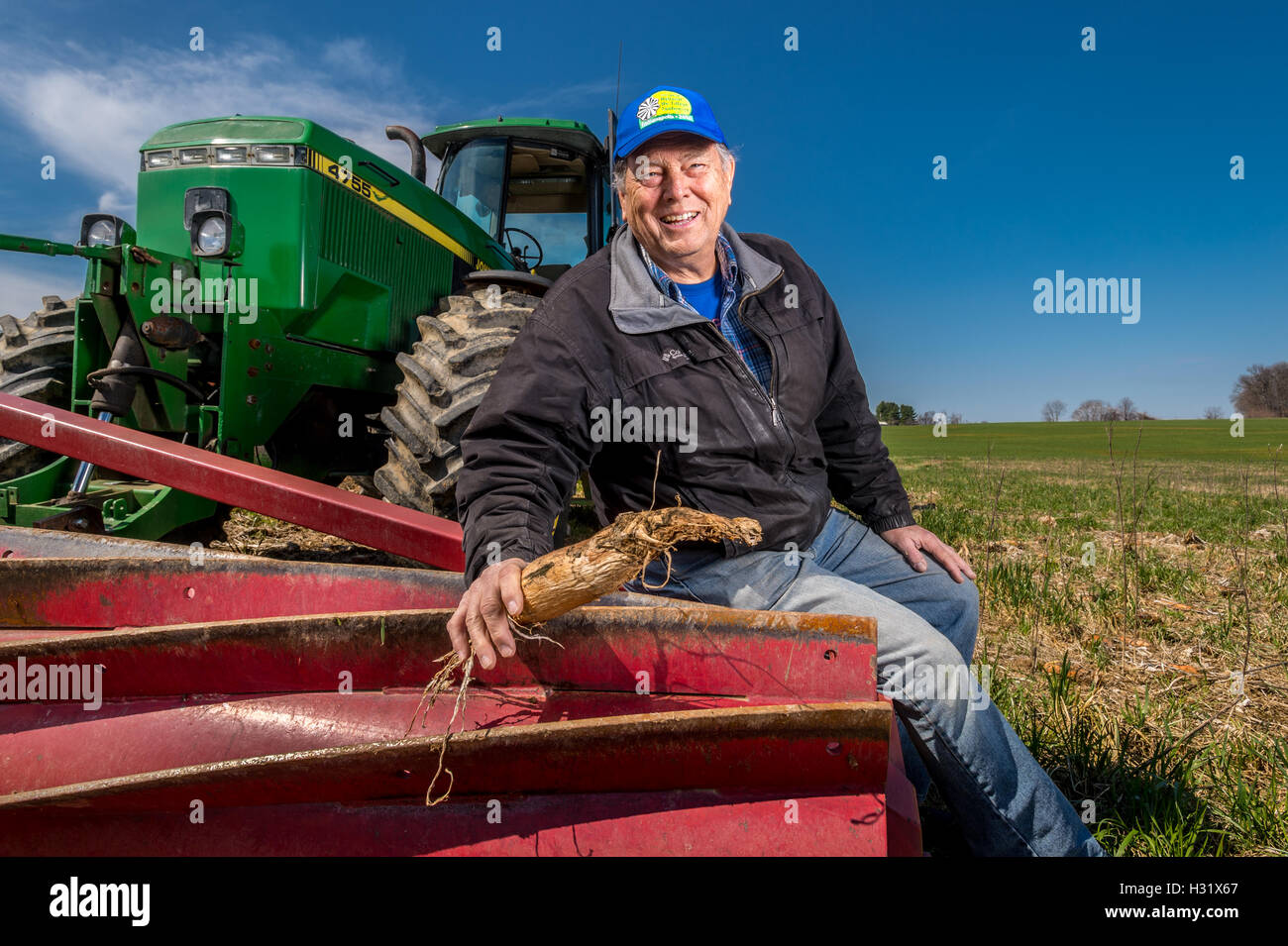 Farmer with Roller Crimper on a John Deere Tractor Stock Photo