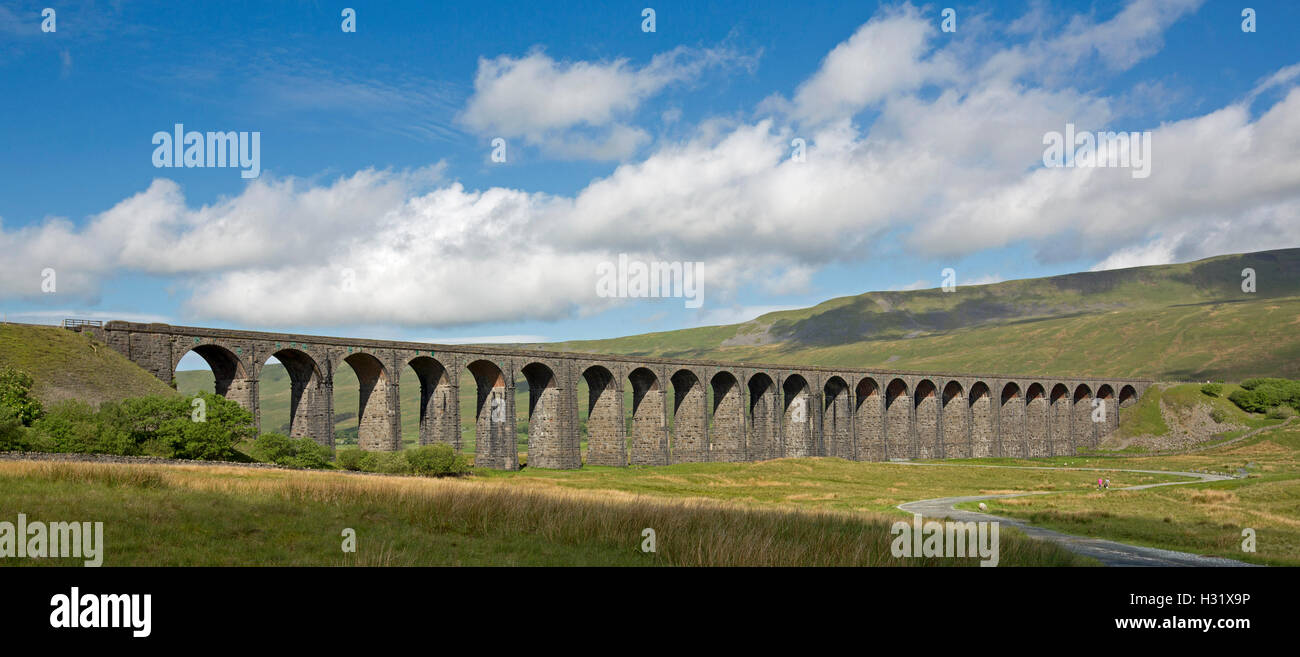 Panoramic view of historic Ripplehead viaduct stretching across valley between barren hills of Yorkshire moors under blue sky in England Stock Photo