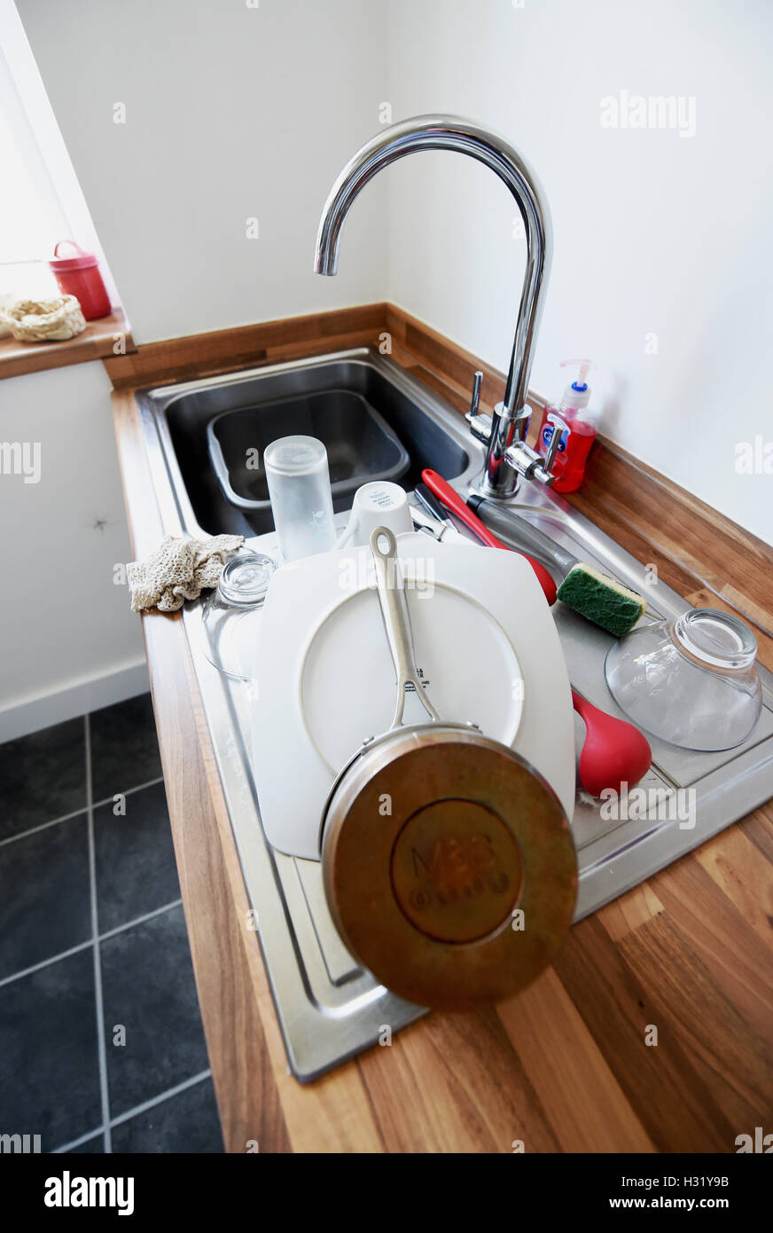 Dishes washing up in kitchen with sink Stock Photo