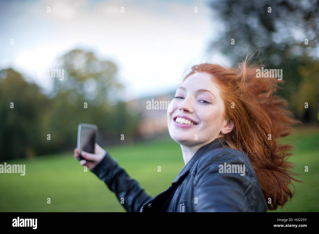 Point of view shot of a woman spinning round. She is holding on to her partners hand and is holding a smartphone. Stock Photo