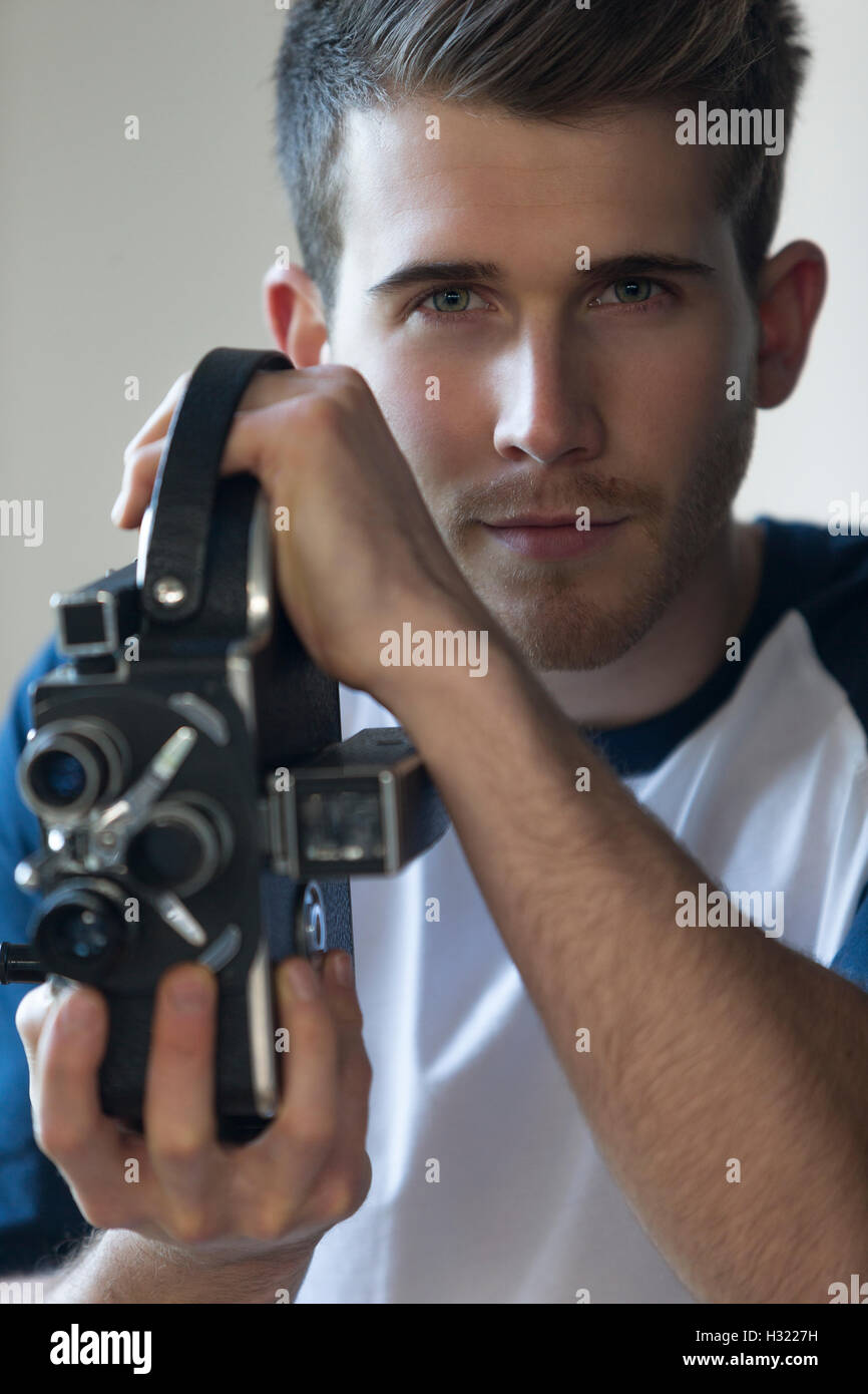 Close up portrait of an attractive young man with a video camera. Stock Photo