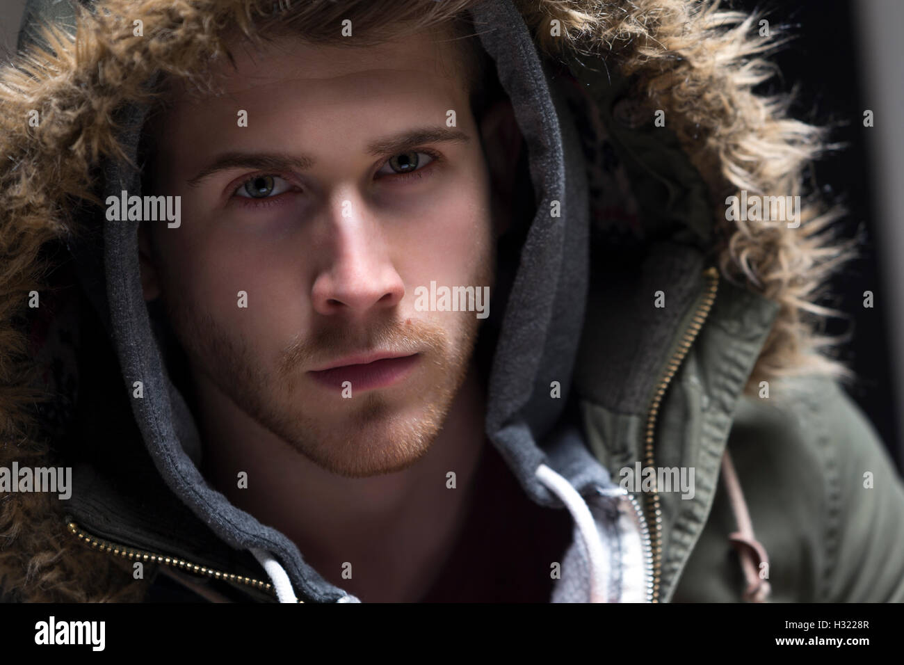 Close up portrait of a young man posing with his hood up. Stock Photo