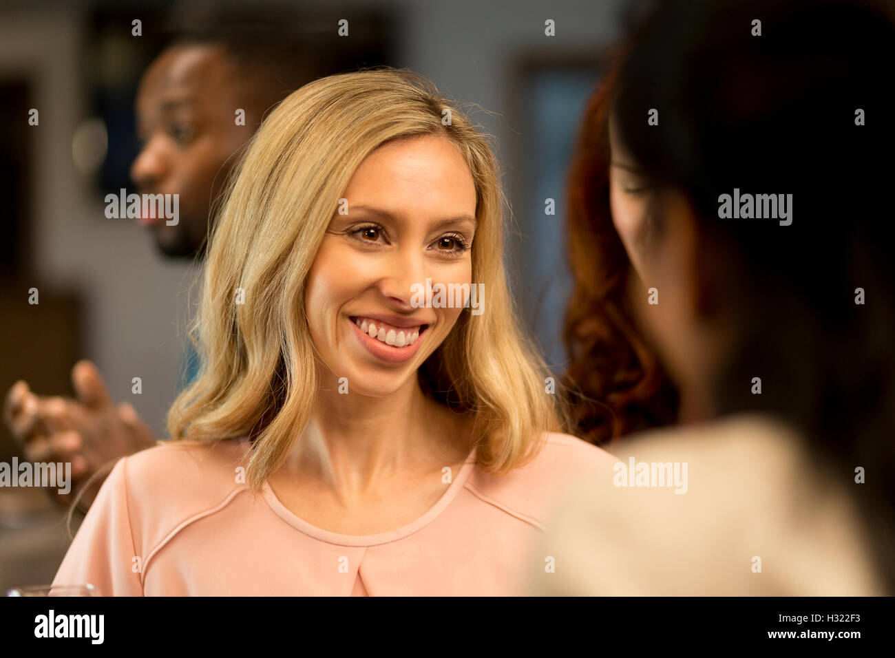 close up shot of a woman talking to her friends at a bar. Stock Photo