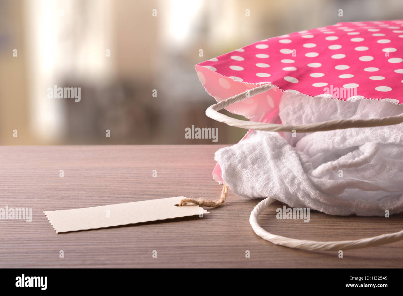 Red bag to buy with white circles on wood table with new clothes inside