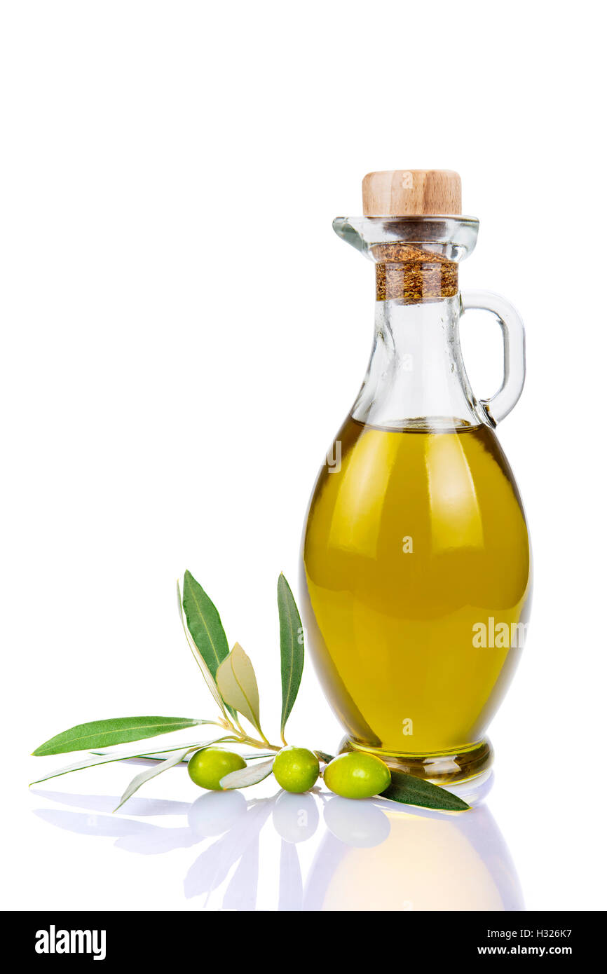 Olive oil in a glass bottle and green olives isolated over a white ...