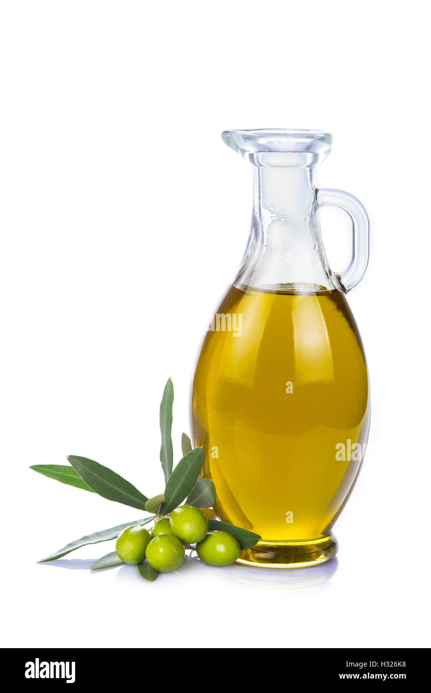 Olive oil in a glass bottle and green olives isolated over a white ...