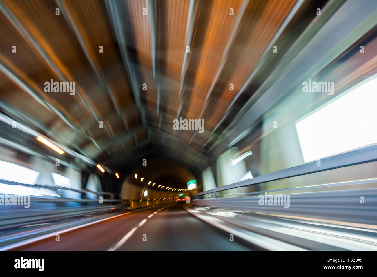 Motion blur driving a car at speed through a road tunnel Stock Photo
