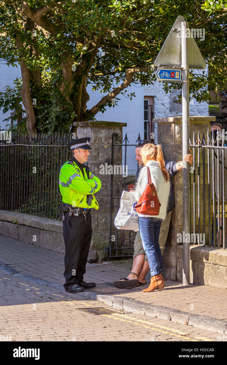 Friendly local policeman chatting to tourists in Tenby Stock Photo