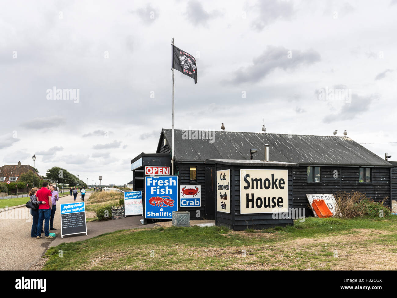 Black wooden eashore hut selling seafood, fresh boiled crab and lobster and smoke house, Aldeburgh on the Suffolk coast, East Anglia, eastern England Stock Photo