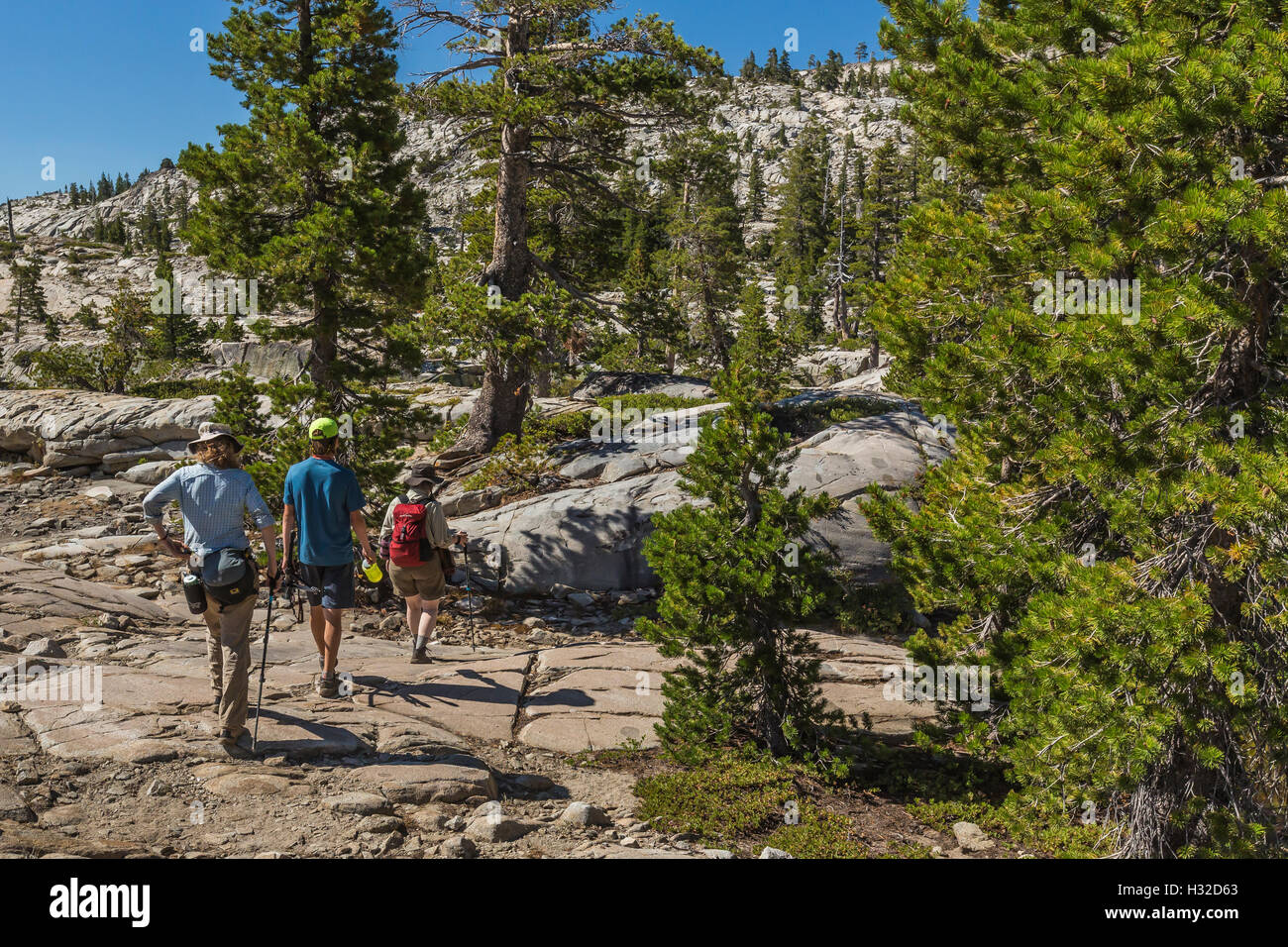 Hikers on granite near Ropi Lake in the Desolation Wilderness, Eldorado National Forest, Sierra Nevada, California, USA Stock Photo