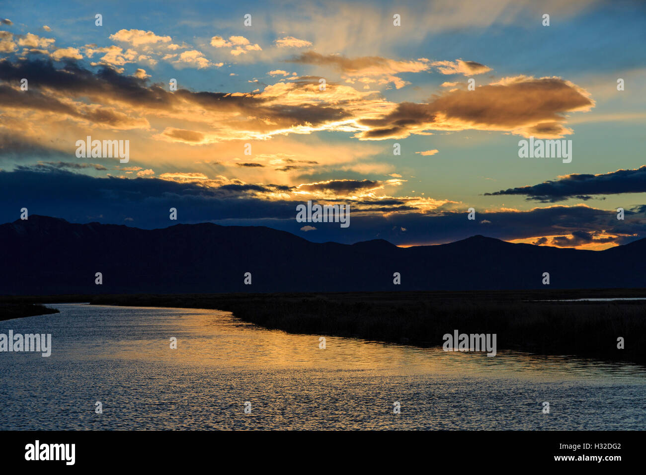 In this view the setting sun reflects on the Bear River at the Bear River Migratory Bird Refuge near Brigham City Utah USA Stock Photo