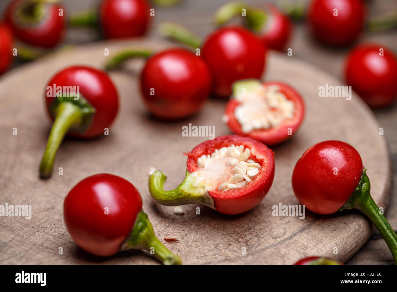 Raw hot cherry peppers on wooden background Stock Photo