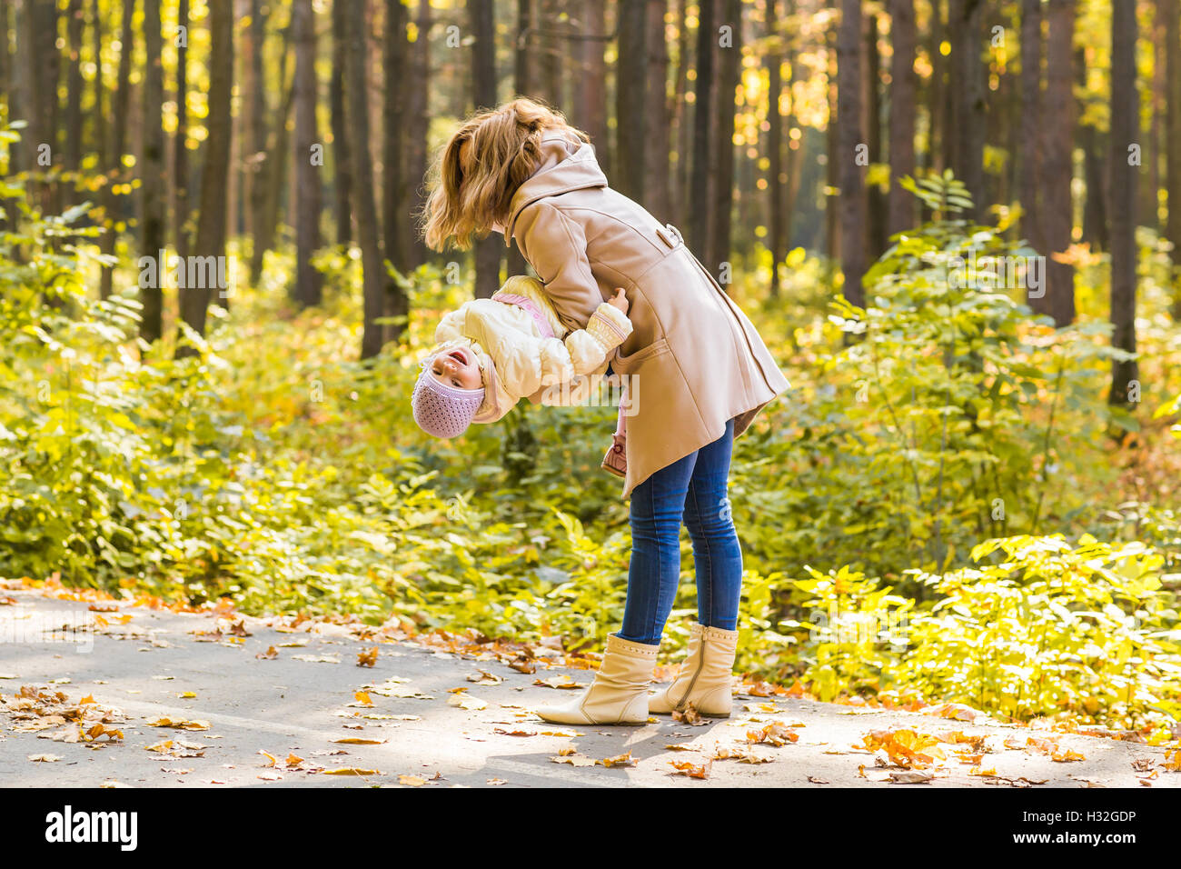Little girl and her mother playing in the autumn park Stock Photo - Alamy