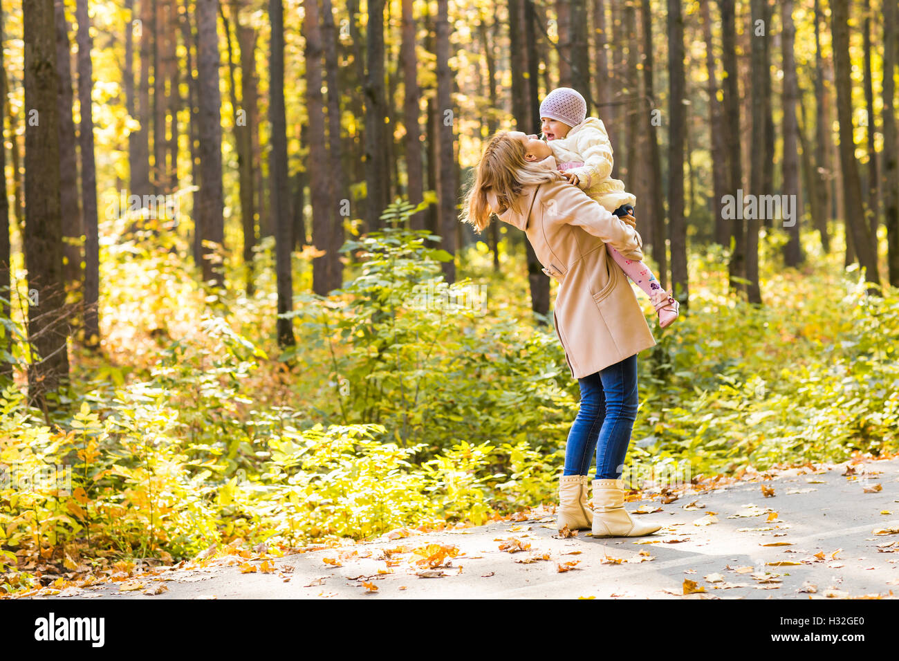 Little girl and her mother playing in the autumn park Stock Photo - Alamy