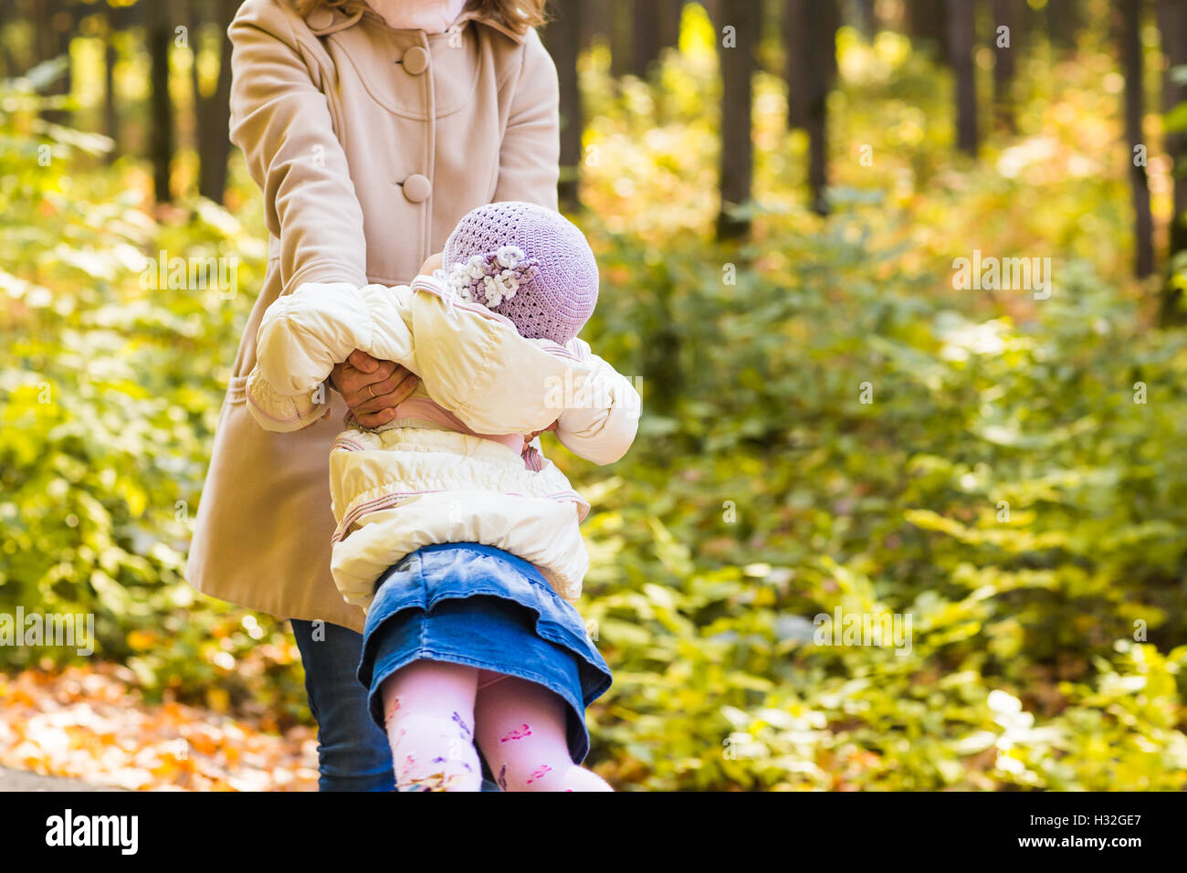Little girl and her mother playing in the autumn park Stock Photo - Alamy