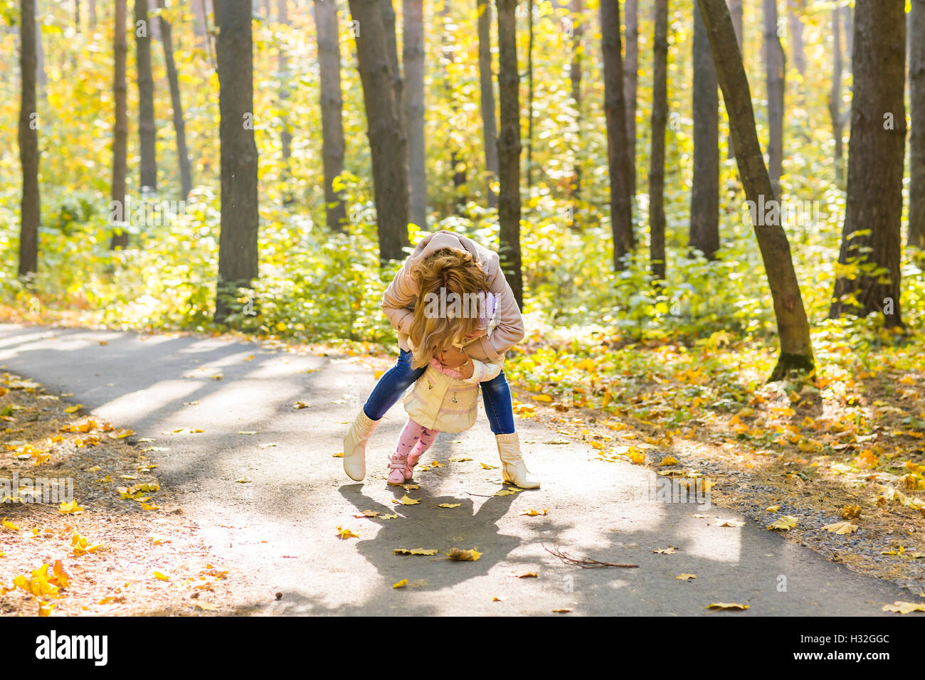 mother and daughter playing together in the autumn park Stock Photo - Alamy