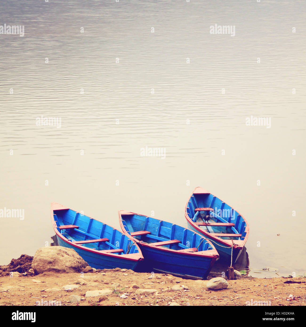 Three boats on the lake with retro filter effect Stock Photo - Alamy