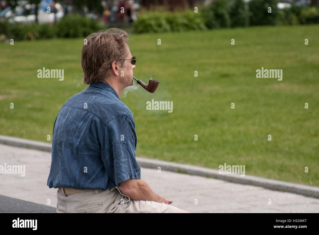 A man is enjoying smoking a pipe Stock Photo