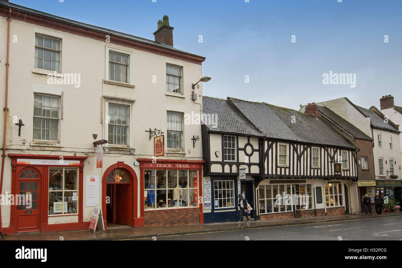 Street in English town of Ashbourne with historic buildings including shops and cafes with people walking on footpath Stock Photo