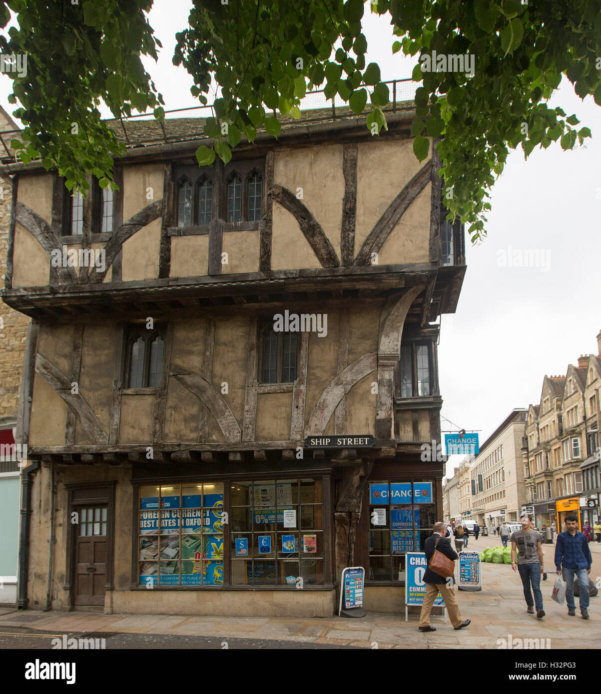 Ancient three story medieval timber building in Cornchurch st Oxford, now used as currency exchange, with people walking past Stock Photo
