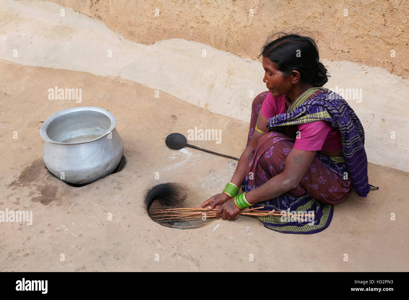 Tribal woman cleaning herth, SAWAR TRIBE, Khairmal Village, Saraipali Tahsil, Mahasamund District, Chattisgarh, India Stock Photo