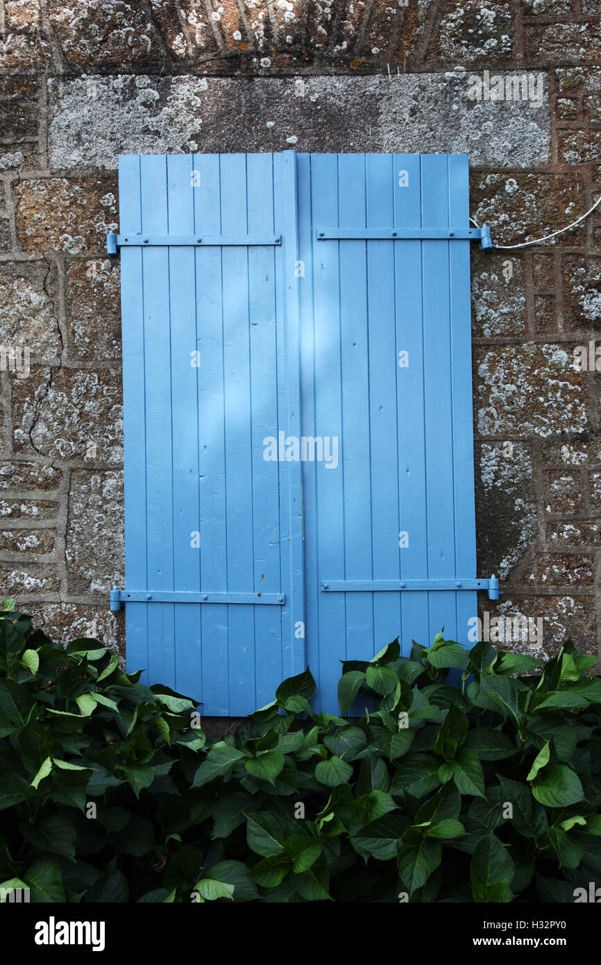 Blue Shutters on a stone house in Normandy, France Stock Photo