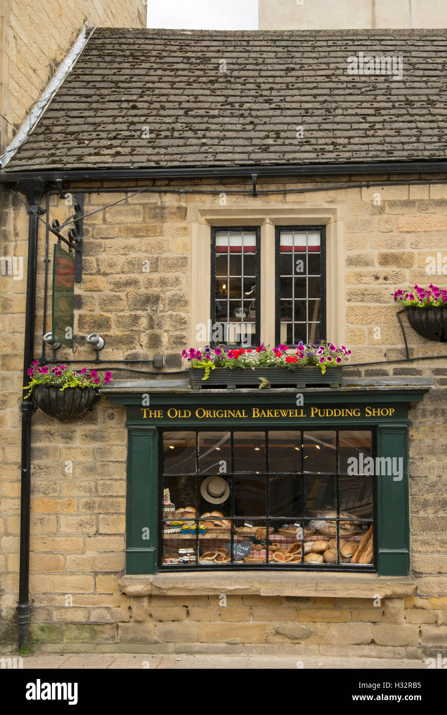 Historic Bakewell pudding shop in brown brick building with food products displayed in window in Derbyshire England Stock Photo