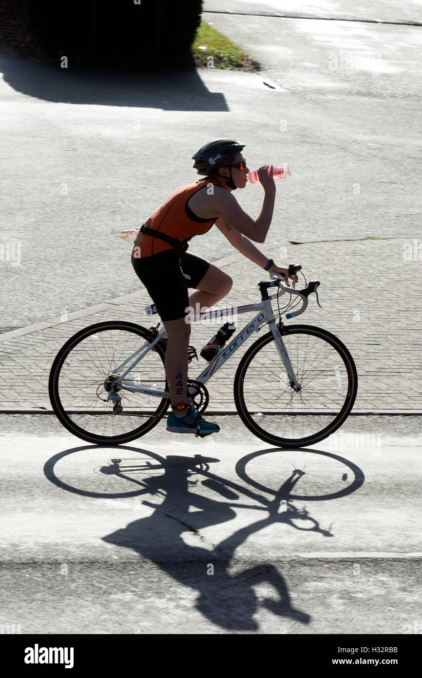 A female competitor having a drink in the Warwickshire Triathlon, Stratford-upon-Avon, UK Stock Photo
