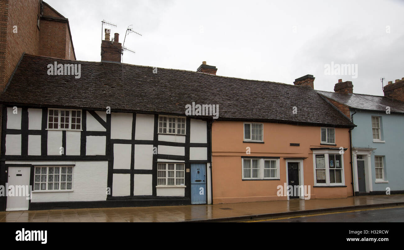 Historic black and white medieval houses beside old terracotta painted house in Stratford-upon-Avon, England Stock Photo