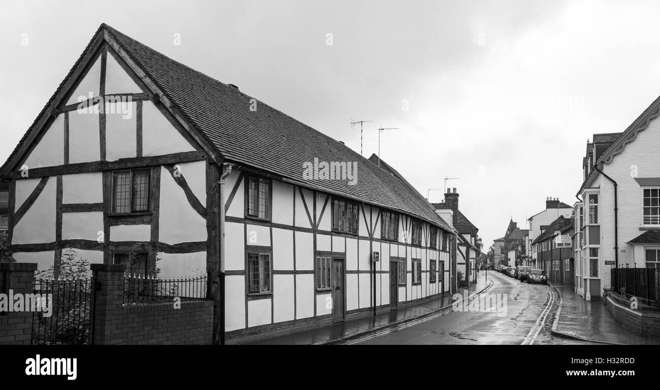 Panoramic view of row of historic black and white medieval houses & other buildings lining street in Stratford-upon-Avon England Stock Photo