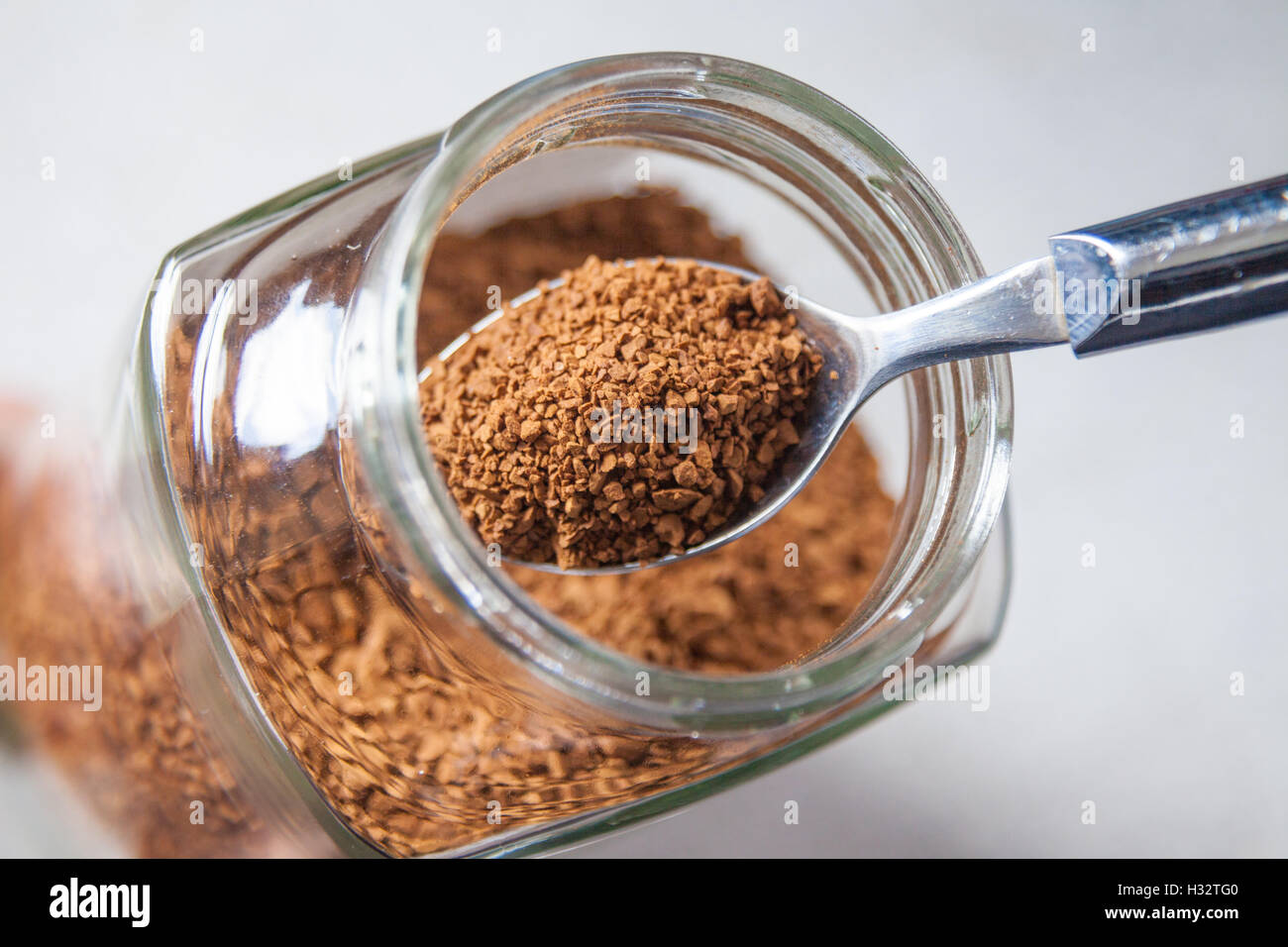 A spoon in a jar of instant coffee granules. Stock Photo