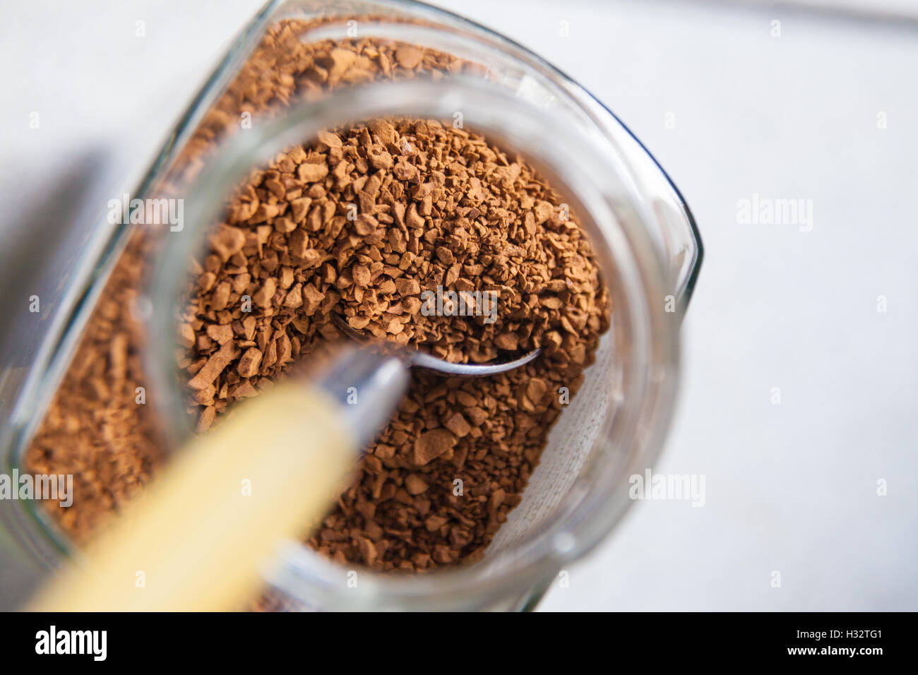 A spoon in a jar of instant coffee granules. Stock Photo