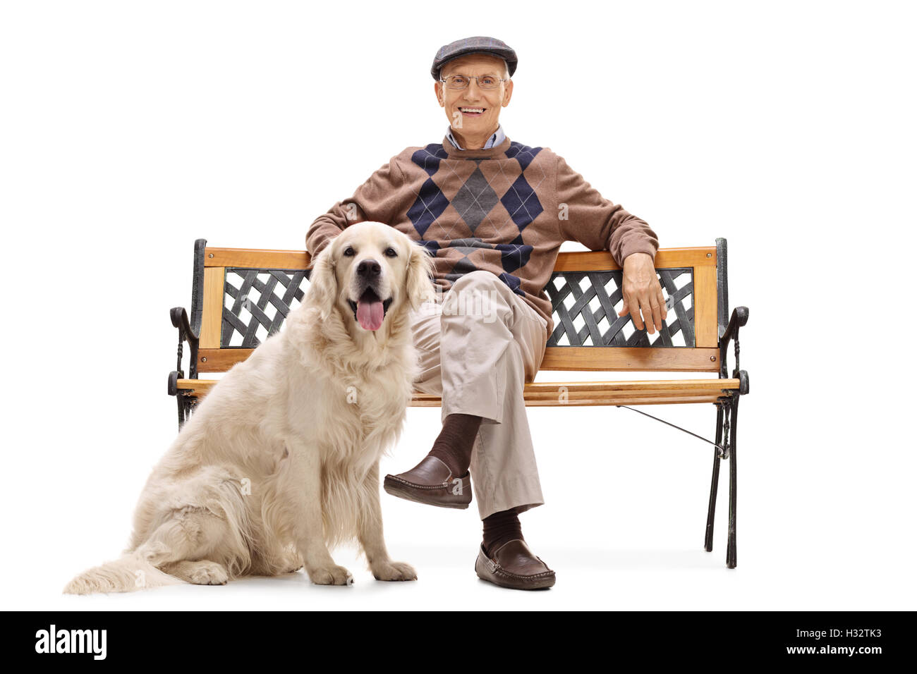 Smiling senior man sitting on a bench with his dog and looking at the ...
