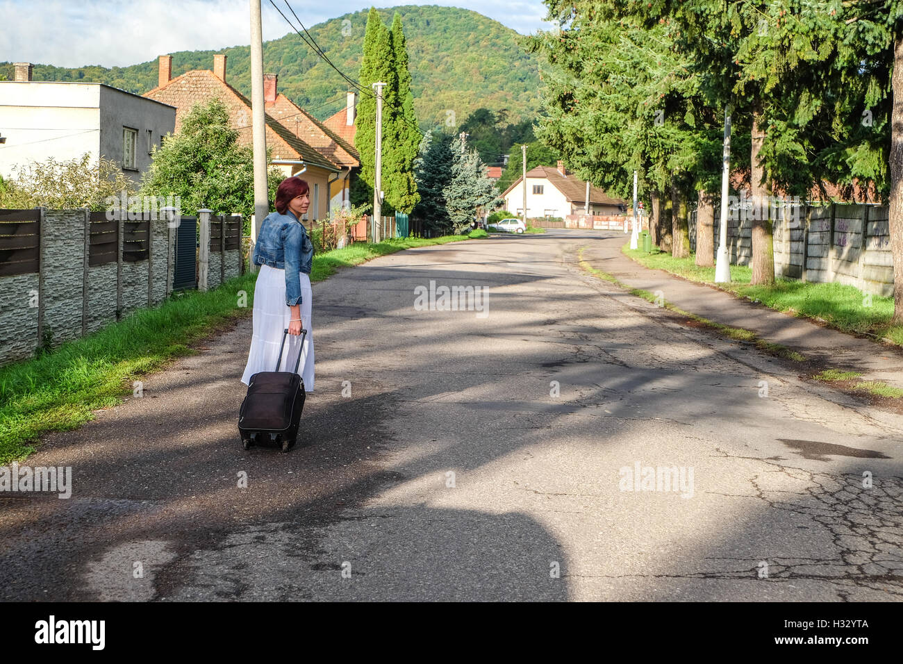 Pretty woman walking with suitcase in Zarnovica, Slovakia Stock Photo