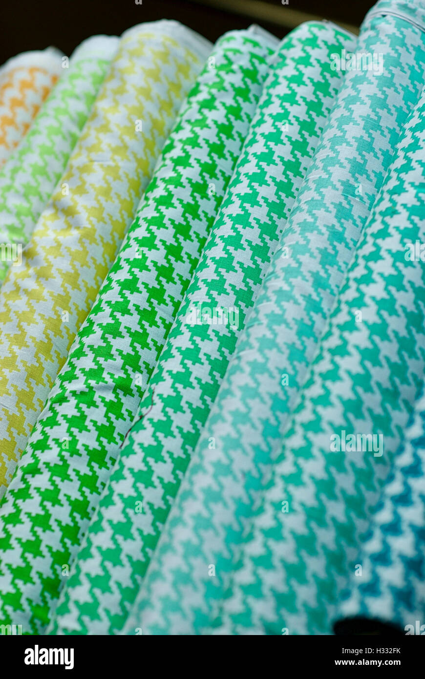 Bolts of colorful fabrics lined up for sale in a variety of styles, patterns, and colors. Stock Photo