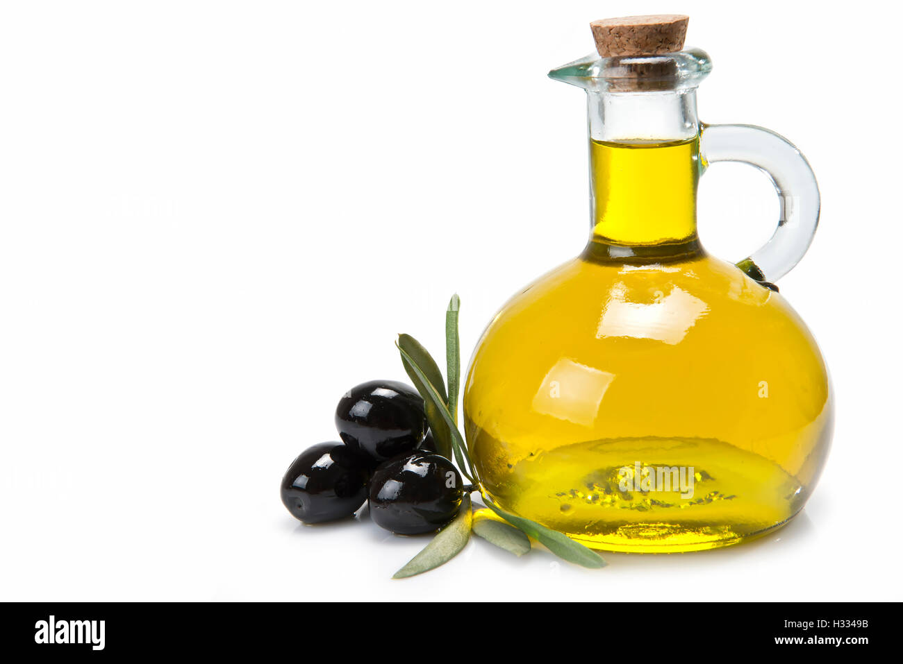 A jar with olive oil and some black olives isolated over a white
