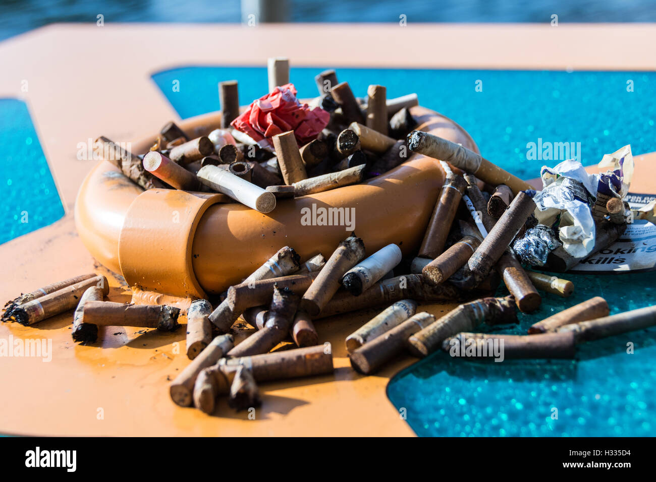 Cigarette butts in a heavily overflowing ashtray Stock Photo