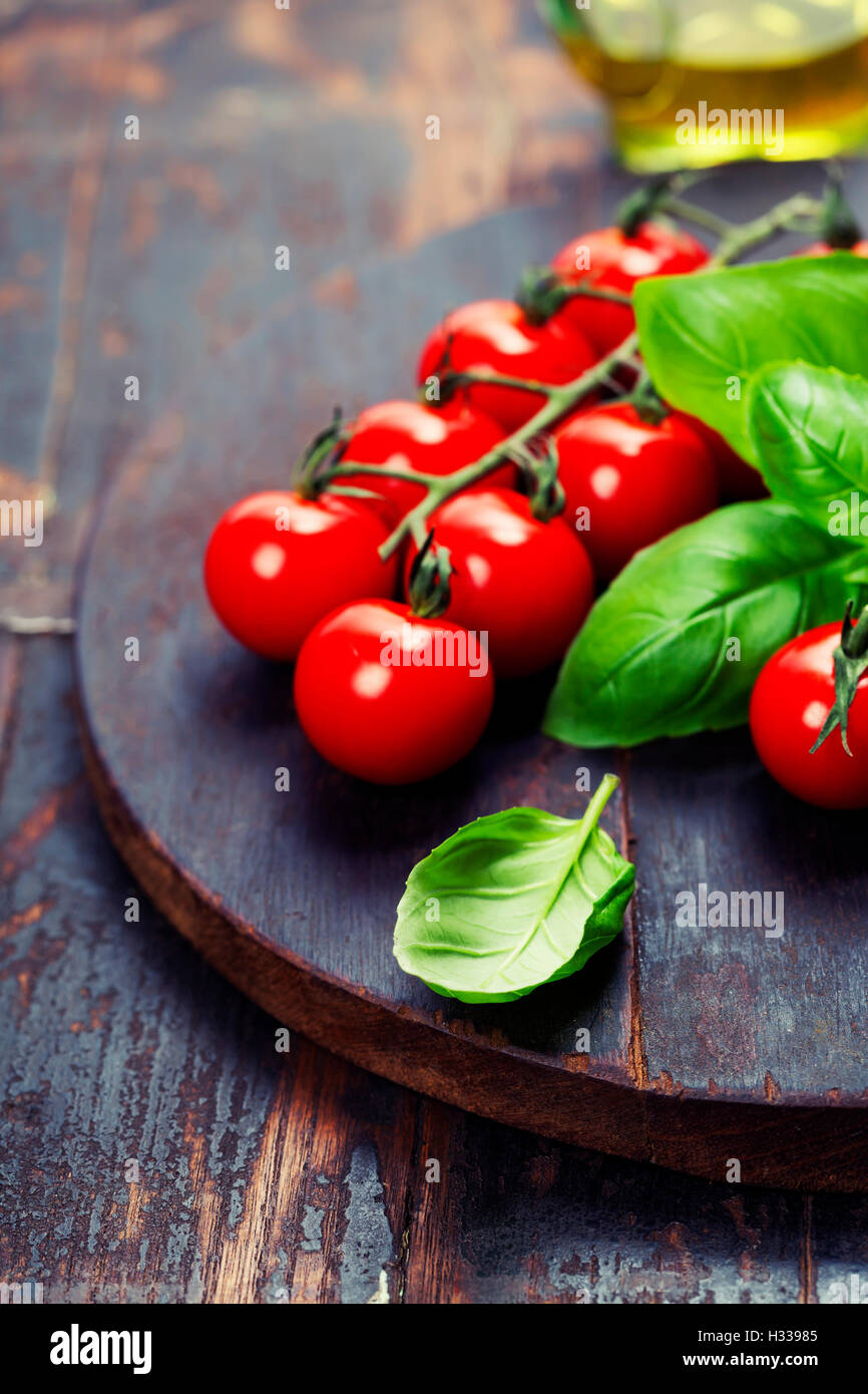 Tomatoes with basil on wooden table background Stock Photo - Alamy