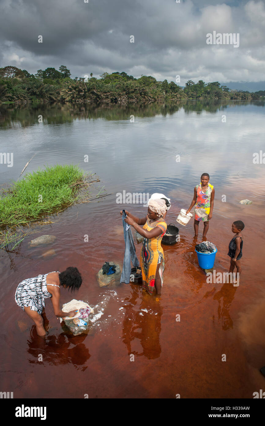 Women washing clothes in the river Ntem, in the rainforest, Campo, Southern Region, Cameroon Stock Photo