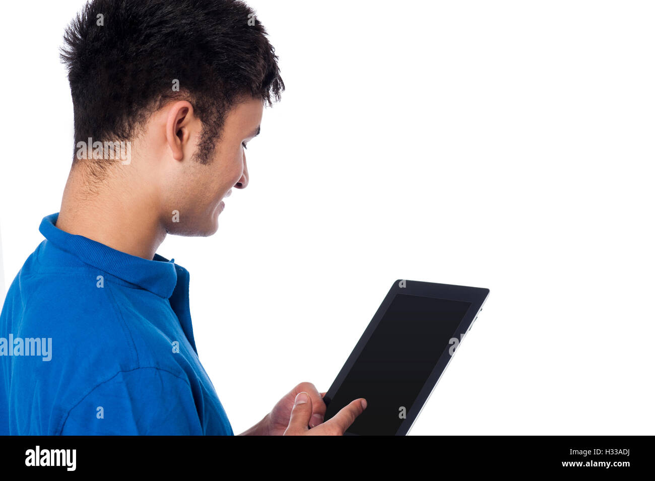 Young guy browsing on tablet device Stock Photo