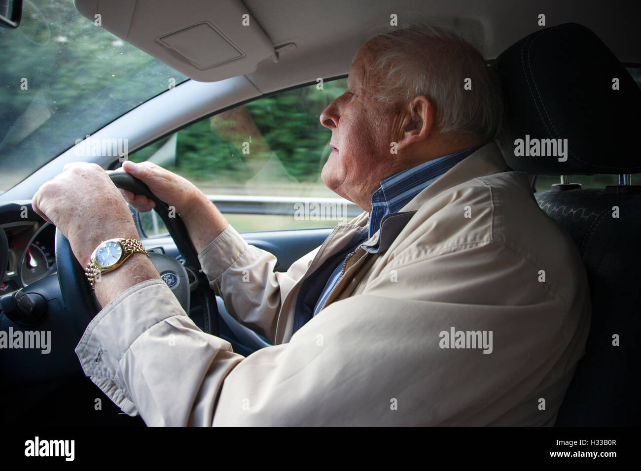 Close up of elderly man (aged 83) driving his automobile, United Kingdom Stock Photo