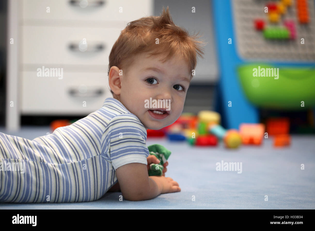 A happy baby boy lying on a floor Stock Photo Alamy