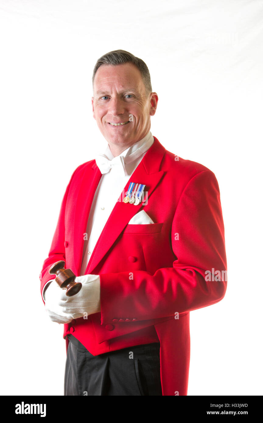 Toastmaster against a black background in traditional red jacket with