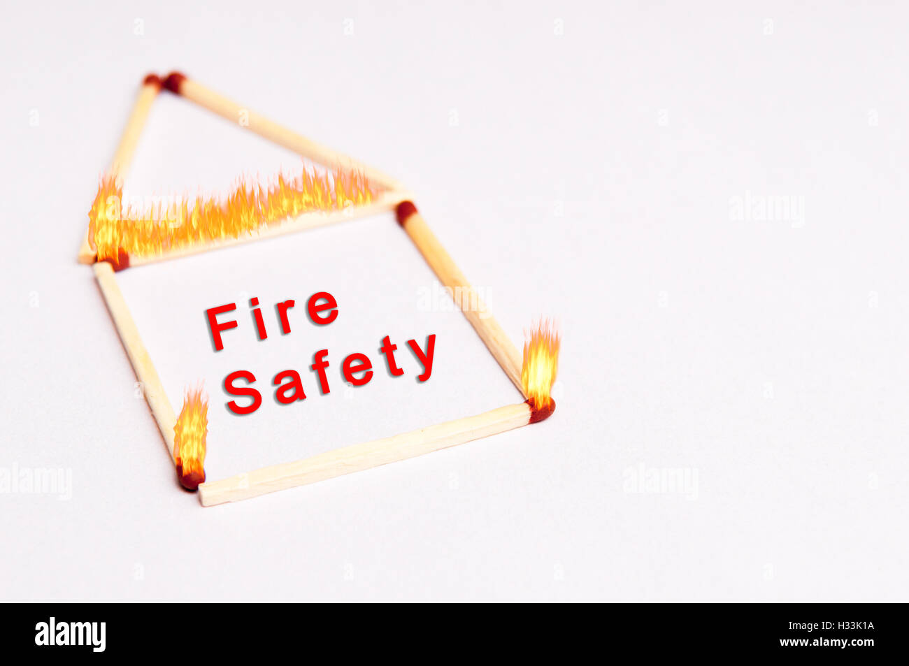 fire safety background concept with matches on fire in the shape of a home Stock Photo