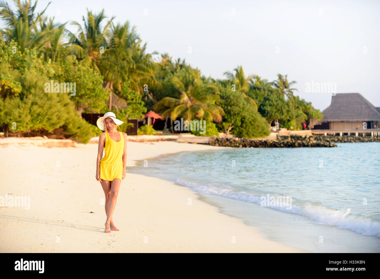 Woman on beach at sunset, Maldives Stock Photo - Alamy