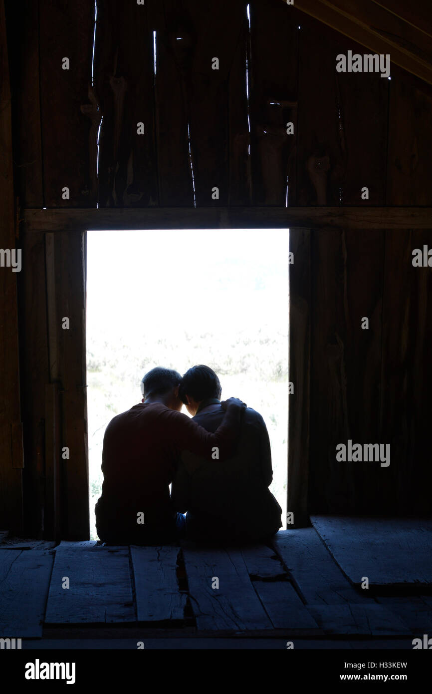 Silhouette of Boyfriend and Girlfriend in love in old barn window Stock Photo