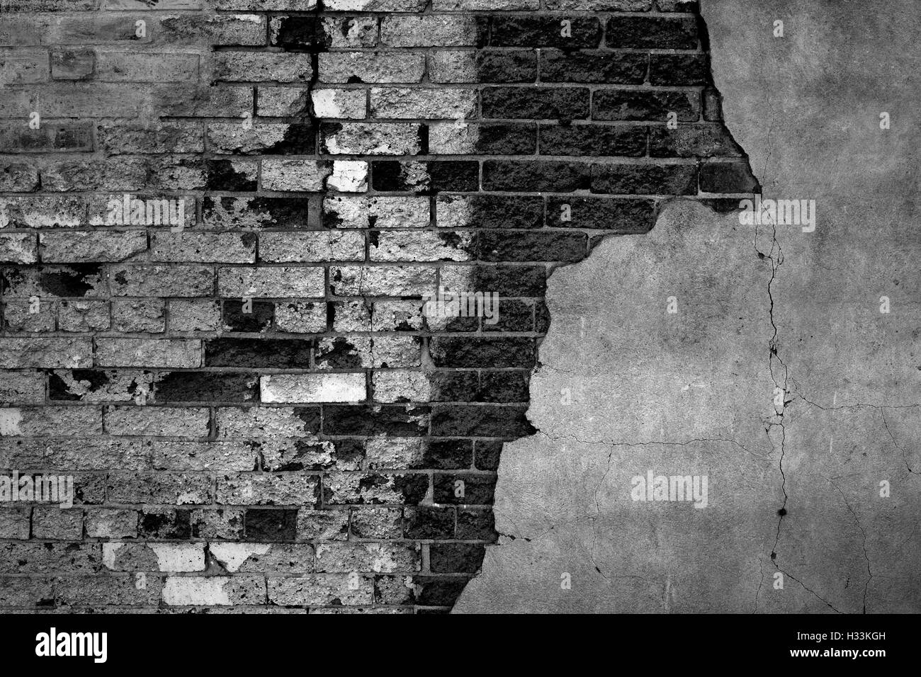 Gray bricks on plastered wall that is falling apart Stock Photo