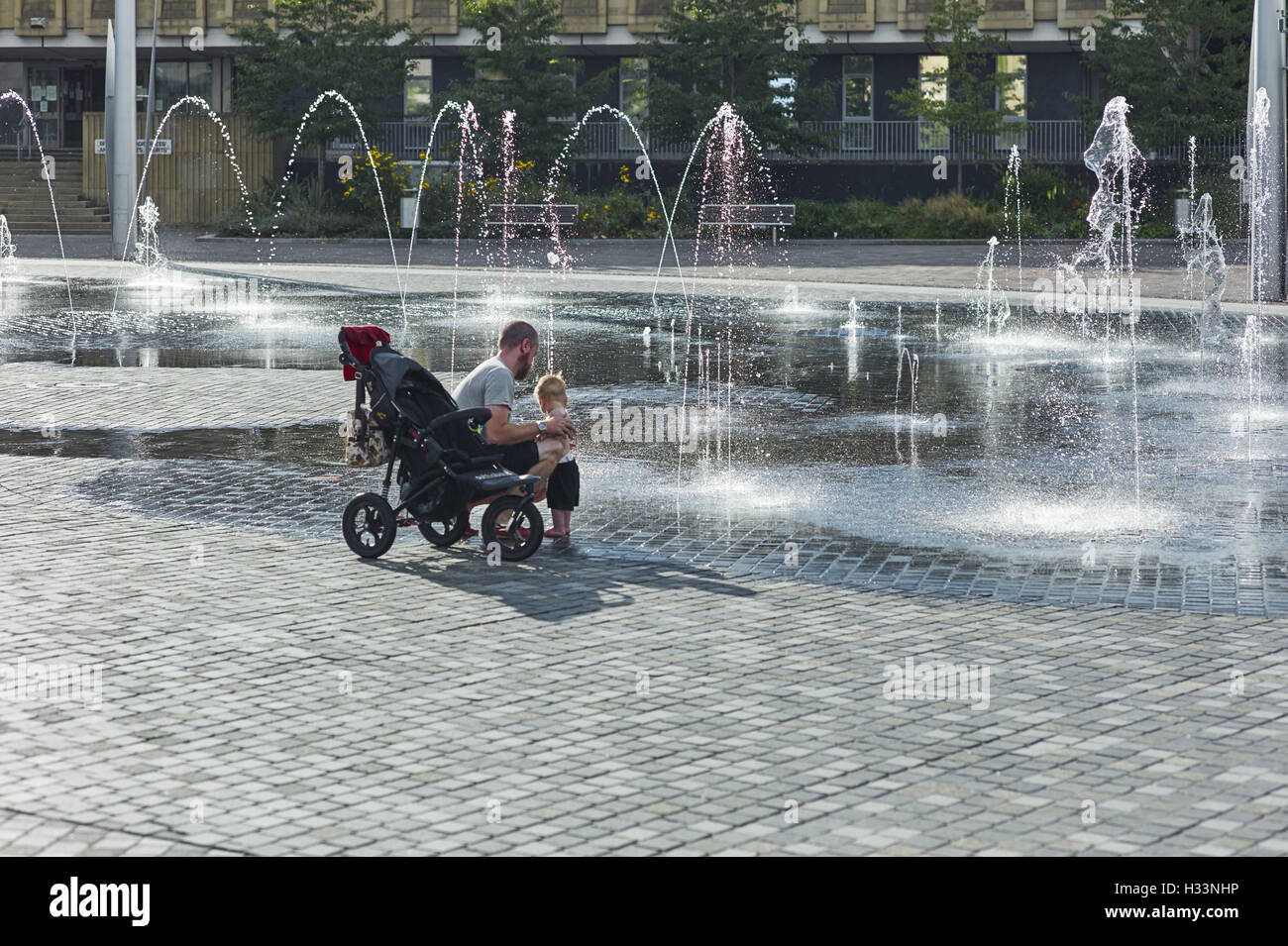Man and child with fountain Stock Photo