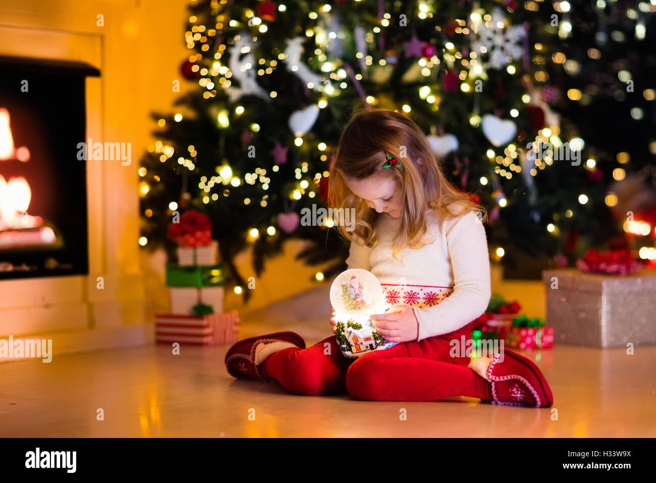 Family On Christmas Eve At Fireplace Little Girl Opening Xmas